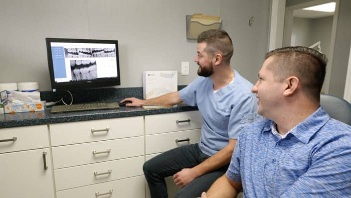 Dr. Bandy looking at teeth x-rays with a patient | Bandy Dental in Holly, MI
